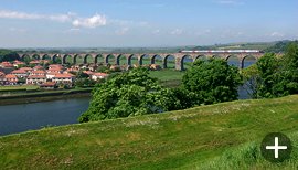 A train heading south across the Royal Border Bridge at Berwick upon Tweed