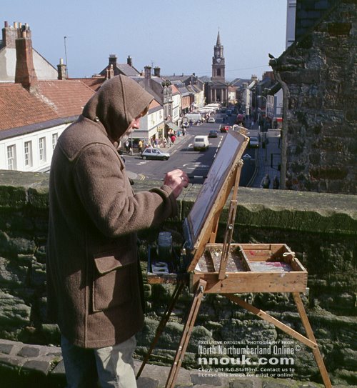An artist at work on the walls overlooking the main street at Berwick upon Tweed. The town was painted by the famous L.S.Lowry too.